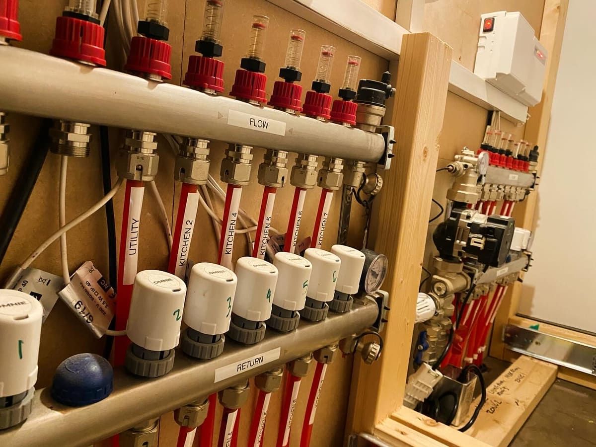 Underfloor heating manifold installed by On Heating, with flow and return pipework labelled per room
