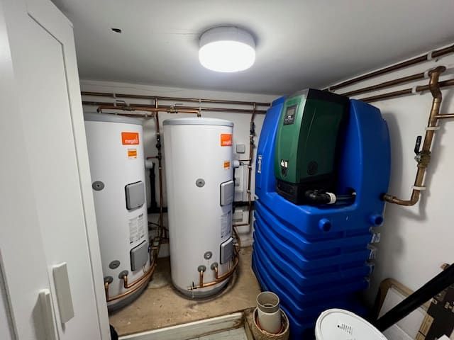 Twin unvented hot water cylinders and expansion vessel installed in an airing cupboard